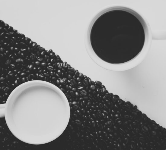 a black and white background with two coffee cups of the opposite color to show division